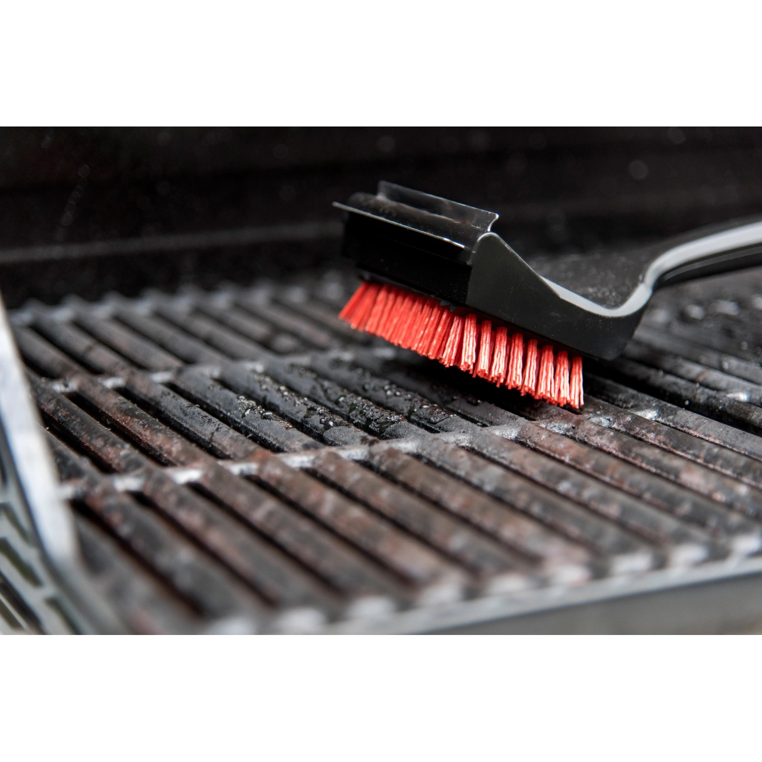Char-Broil Grillbürste Cool Clean Premium bei der Reinigung eines Grillrosts.