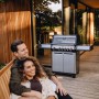 Enders Gasgrill Monroe Pro 4 SIKR Turbo mit Paar auf Holzterrasse. Edelstahl Gasgrill mit Seitenkocher.