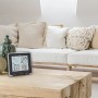 Schwarze TFA Funk-Wetterstation Life mit Sensor-Touch auf Holztisch im Wohnzimmer.
