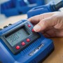 Blaue LUX-TOOLS Lötstation LST-60 mit digitaler Temperaturanzeige und Hand am Bedienknopf.
