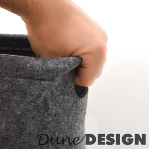 Hand greift in den Griff einer anthrazitgrauen Filz Aufbewahrungsbox. Praktische Lösung für Toilettenpapier & Ordnung.