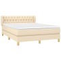 Cremefarbenes Boxspringbett 140x200 cm mit Matratze und gestepptem Kopfteil.