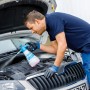 Mann reinigt Auto-Motor mit Gloria CleanMaster Extreme EX 100 Drucksprühgerät.