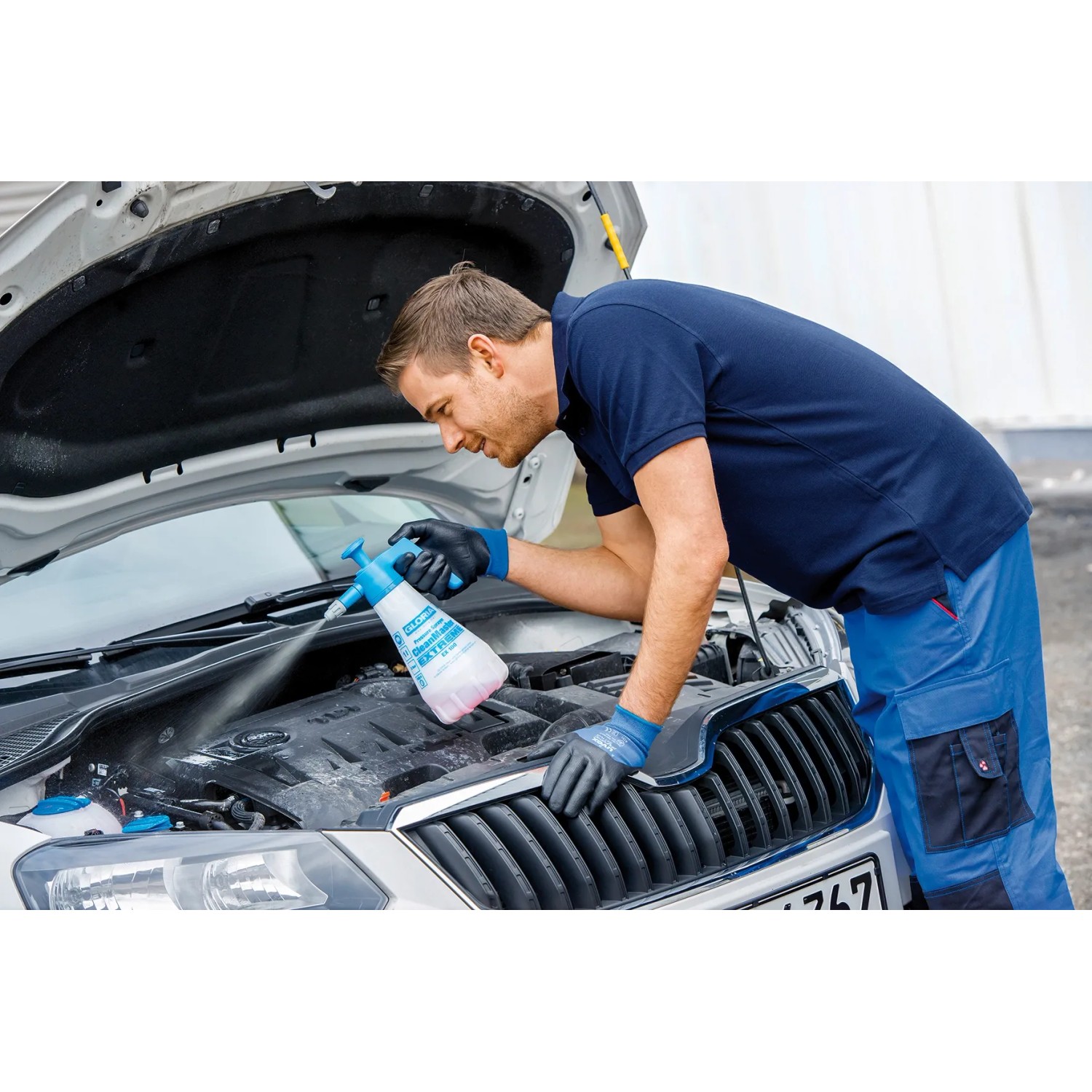 Mann reinigt Auto-Motor mit Gloria CleanMaster Extreme EX 100 Drucksprühgerät.