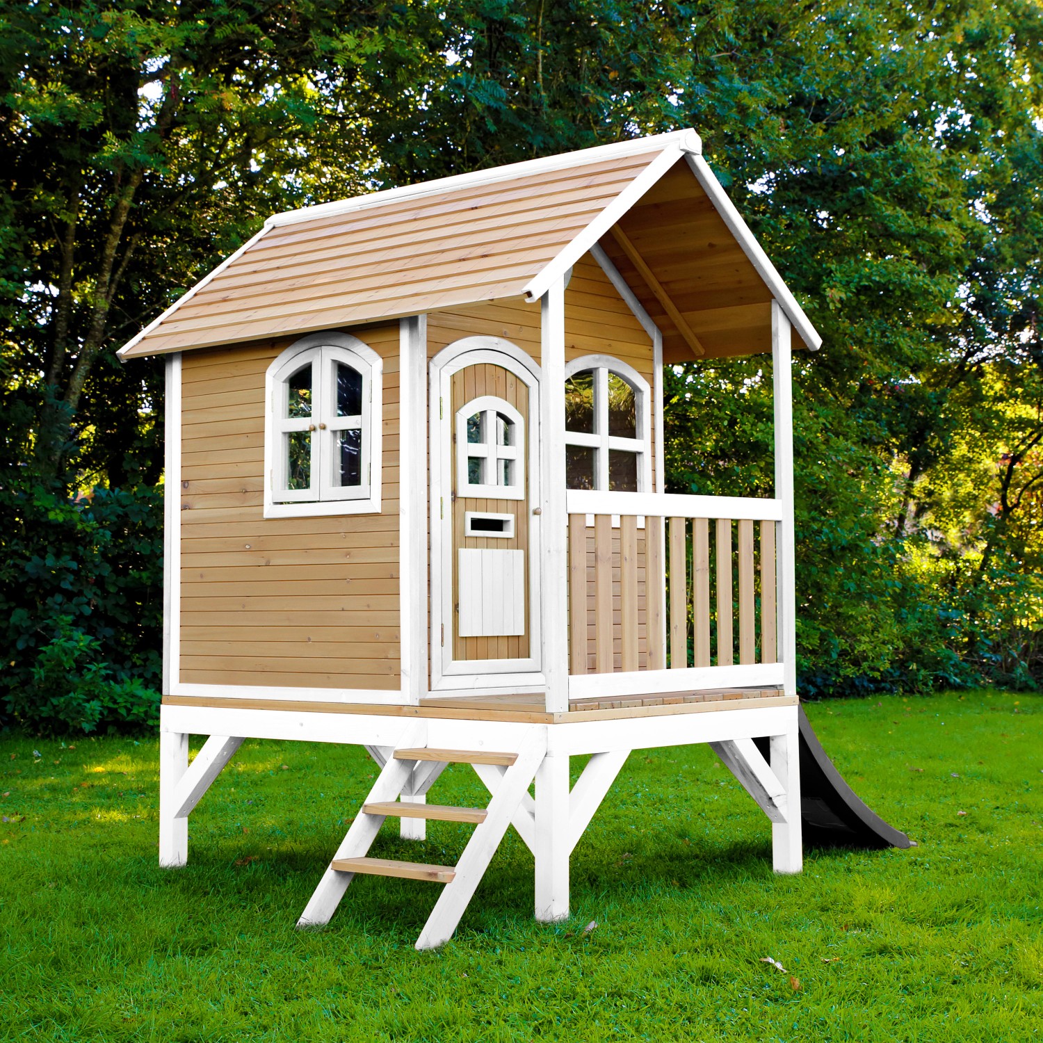 Axi Tom Spielhaus aus Holz, braun-weiß mit grauer Rutsche, Leiter und Veranda im Garten.