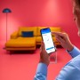 Mann steuert WiZ LED Deckenleuchte per App. Smarte Lampe mit WLAN steuern.