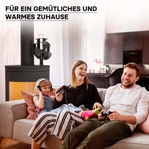 Schwarzer Wiltec Kaminofen Ventilator mit 3 Blättern auf einem Ofen. Eine Familie entspannt im warmen Wohnzimmer.