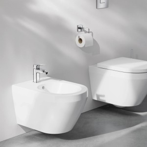 Grohe Einhand-Bidetarmatur Dice Chrom auf weißem Wand-Bidet im modernen Bad. Eleganter Einhebelmischer mit kubischem Design.