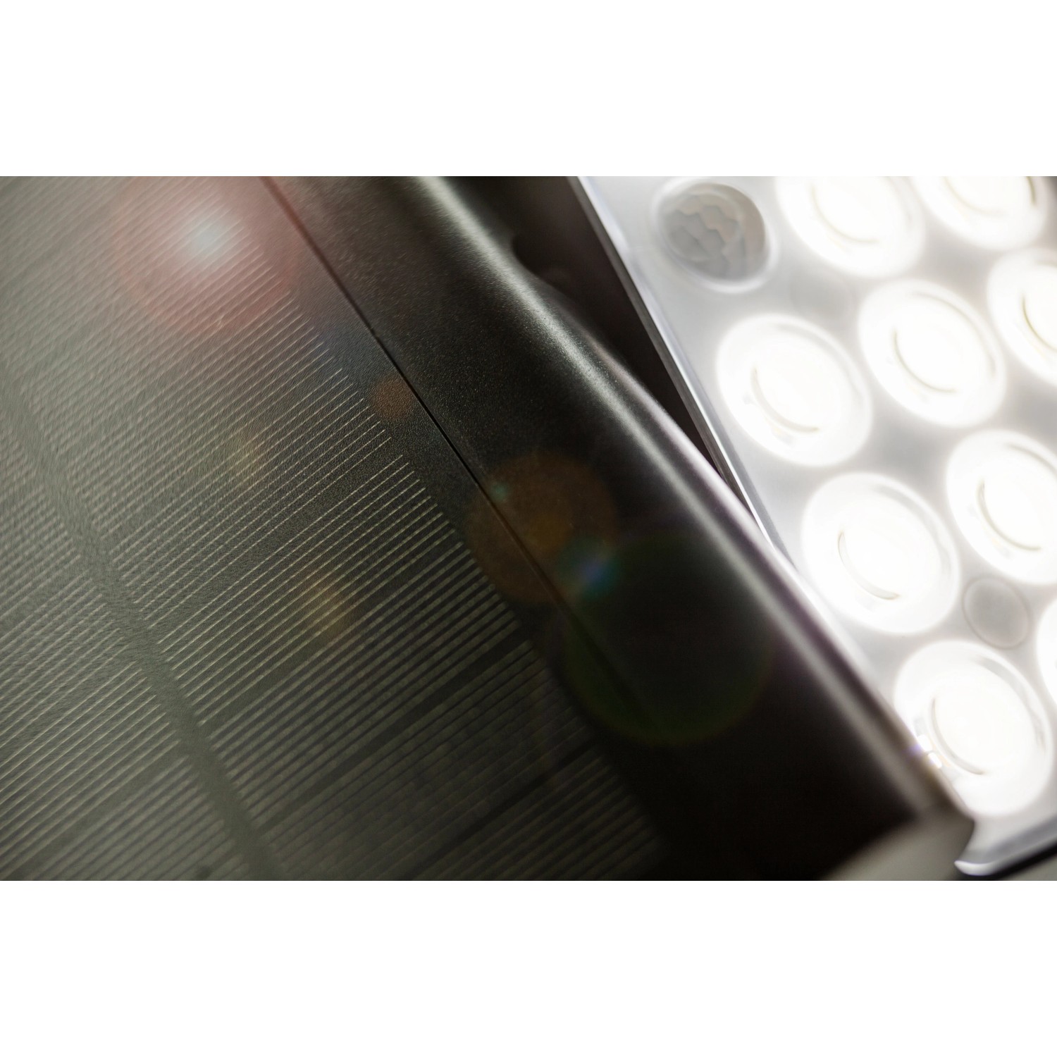 Detailaufnahme der schwarzen Lutec LED-Solarleuchte Tuda mit Solarpanel und LED-Leuchtköpfen.