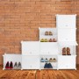 Weißer Relaxdays Schuhschrank aus Kunststoff/Metall, modulares Stecksystem mit 24 Fächern, gefüllt mit Schuhen, vor Ziegelwand.