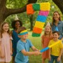 Bunte Zahl 7 Pinata hängt an Baum. Junge mit Augenbinde schlägt mit Stab, Kinder feiern Geburtstagsparty.