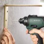 Bosch AdvancedDrill 18 Akkuschrauber beim Schrauben eines Winkels an eine Wand.