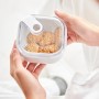 Weiße Rotho Frischhaltedose Ela 1 l, flach, mit Keksen in Händen gehalten.