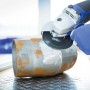 LUX Fiberscheibe Classic im Einsatz: Winkelschleifer beim Entrosten eines Metallrohrs.