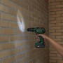 Bosch Akku-Bohrschrauber Advanced Drill 18V-80 beim Bohren in eine Ziegelwand.