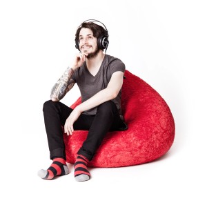 Mann sitzt entspannt auf grünem Sitting Point Sitzsack Fluffy 120 l. Gemütlicher Sitzsack für Kinderzimmer.