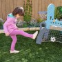 Kind spielt Fußball am KidKraft 5 in 1 Klettergerüst mit Rutsche, Fußballtor & Basketballkorb im Garten.