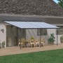 Graue Palram Canopia Terrassenüberdachung Sierra (619x295cm) mit Tisch und Stühlen.