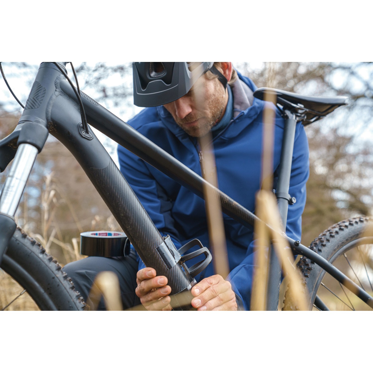 Mann repariert Fahrradrahmen mit Tesa Ultra Power Extreme Reparaturband.