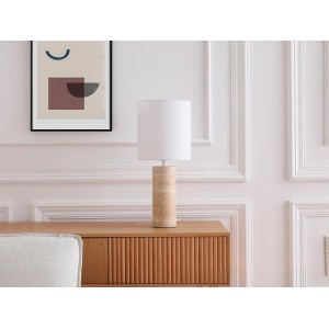 Vente-unique Tischlampe Zapana mit hellem Travertin-Sockel und weißem Schirm auf Holzkommode.