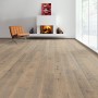 Verlegtes Living by Haro Parkett Eiche Tabakgrau Landhausdiele mit Kamin und Sessel im Raum.