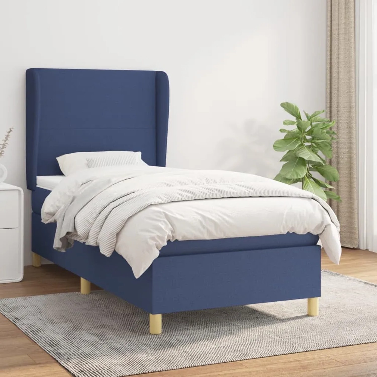 Blaues Boxspringbett 90x190 cm mit Matratze und Stoffbezug.