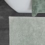 Schöner Wohnen Badteppich Bahamas in Mint, 67x110 cm, vor Badewanne auf grauem Boden.