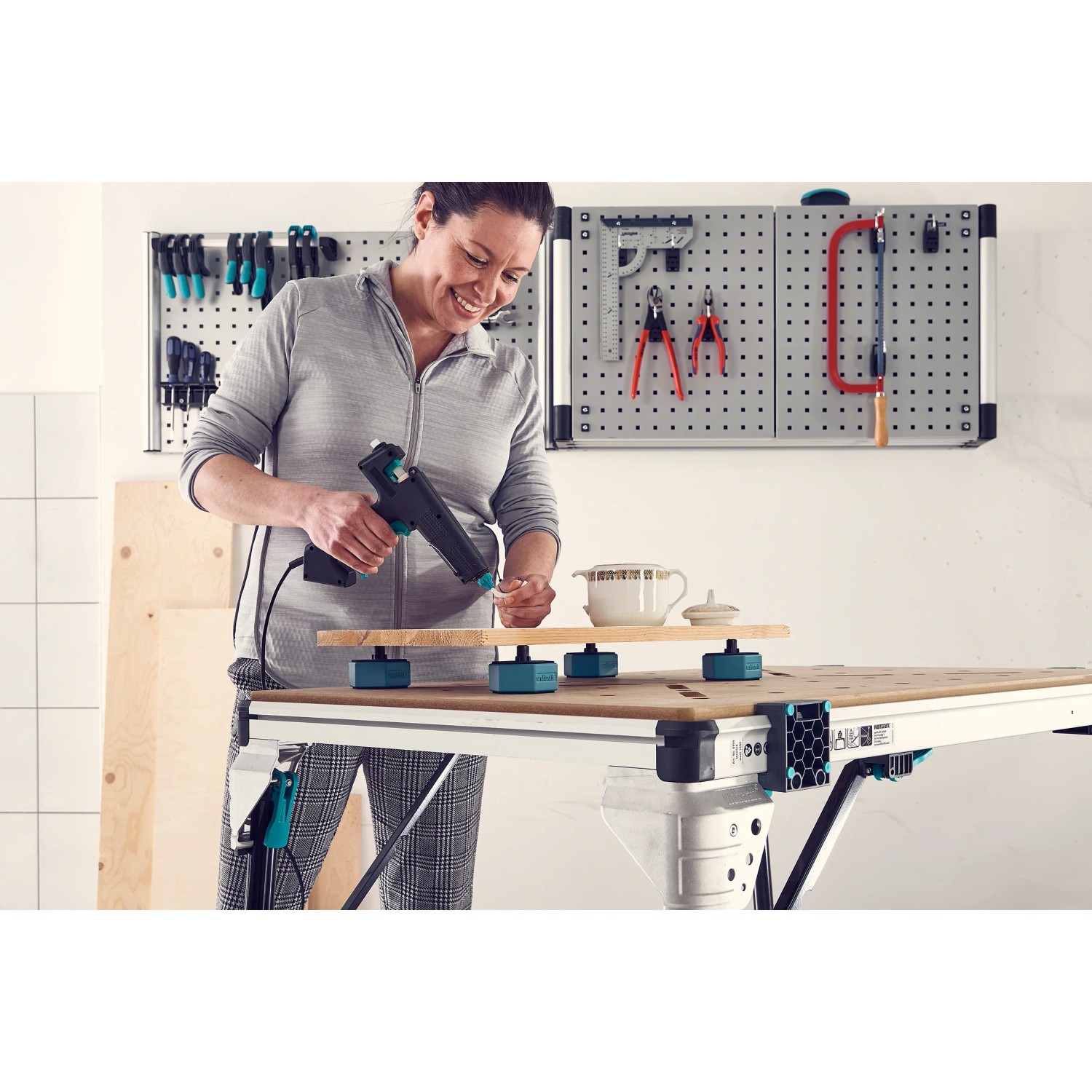 Frau arbeitet mit Werkstückauflagen-Set von wolfcraft auf einer Werkbank.
