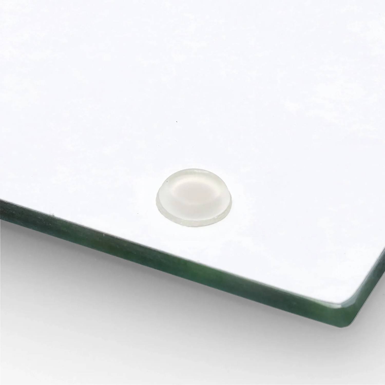 Detailaufnahme einer schwarzen Zeller Herdabdeckplatte aus Glas mit Silikonfuß.