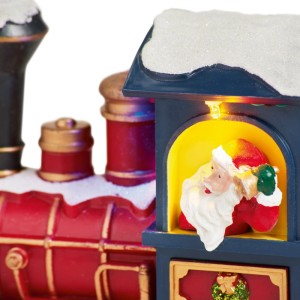 Beleuchteter OBI Weihnachtsdorf Zug mit Schnee, roter Lok und blauem Waggon, darin ein leuchtender Weihnachtsmann.