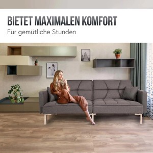 Graues MCW Schlafsofa K65 aus Stoff mit Frau und Kissen im Wohnzimmer.