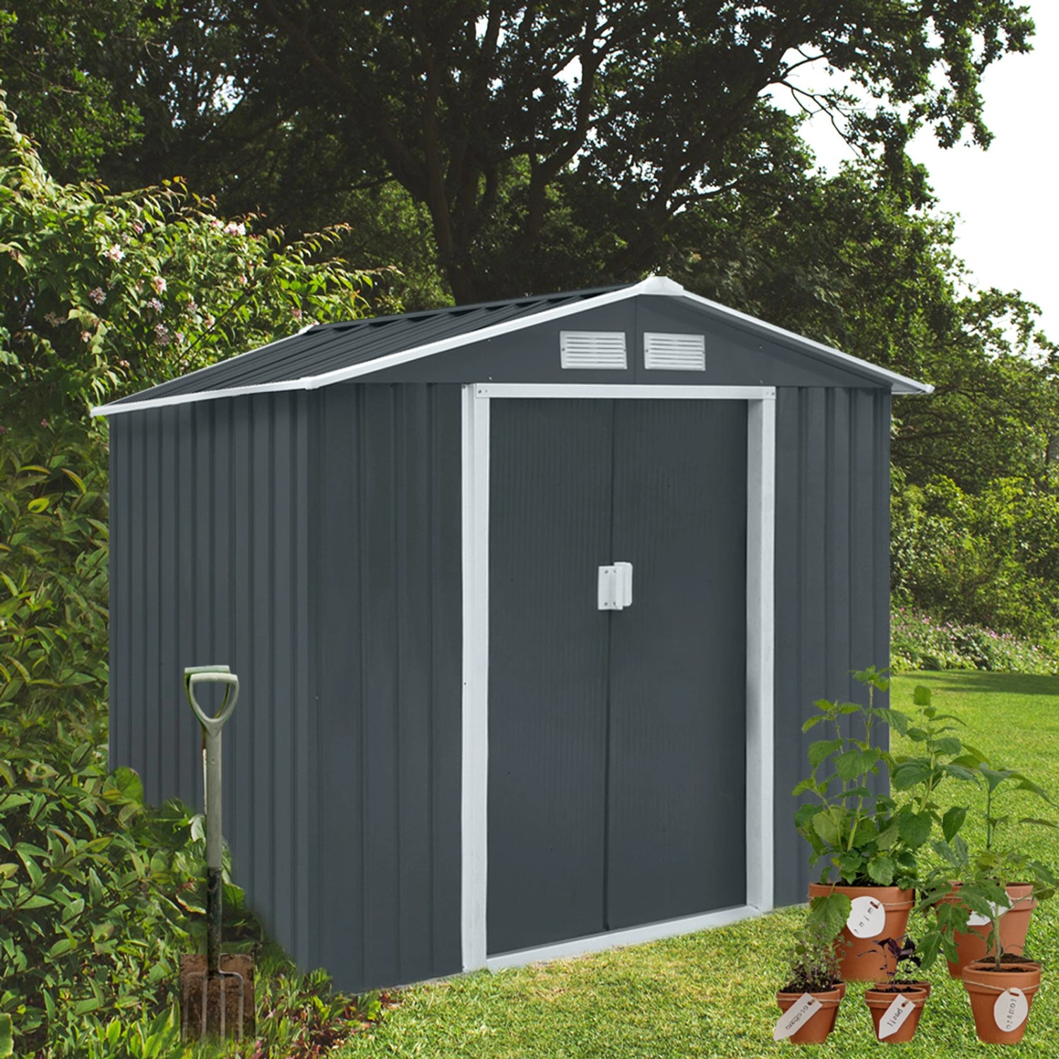 Graues Metall Gerätehaus Hattoro S100 XL im Garten mit Schaufel und Pflanzen.