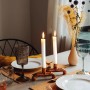 DIY Kerzenständer aus Kupfer von CREATE! by OBI auf gedecktem Tisch mit brennenden Kerzen.