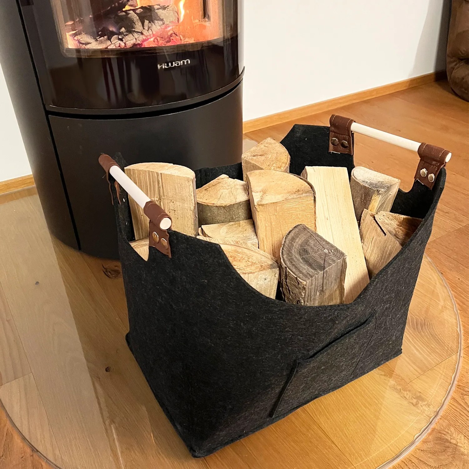 Schwarze KARAT Filztasche Vesta als Kaminholztasche mit Holzscheiten gefüllt.