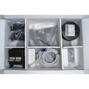 Ambrogio Kit Smart System Zeta R: Ladestation, Kabel und Zubehör für Rasenroboter in geöffneter Verpackung.