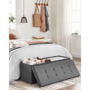 Graue Songmics Polsterbank mit Stauraum vor Bett. Schuhbank mit hochklappbarem Deckel.