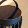 Schwarze Lutec Solar Tischleuchte Kozy mit Gitterstruktur und Tragegriff, Ø 13,7 cm.