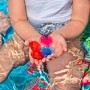 Kind im Bestway Family Pool mit bunten Spielkristallen in den Händen. Planschbecken mit 3D Unterwasserwelt.