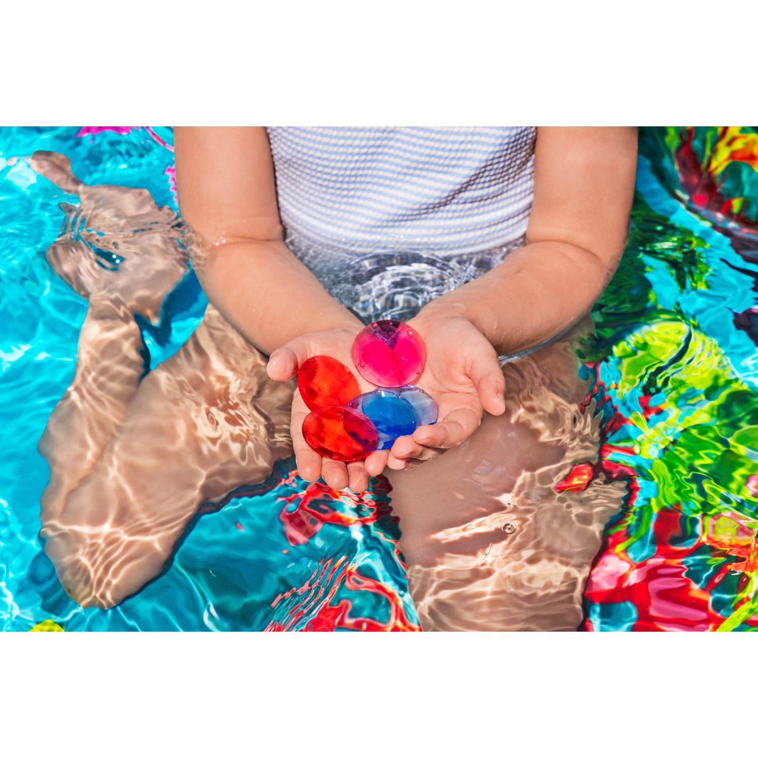 Kind im Bestway Family Pool mit bunten Spielkristallen in den Händen. Planschbecken mit 3D Unterwasserwelt.