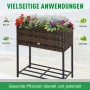 Outsunny Blumenkasten aus Rattan mit Füßen und Ablage, bepflanzt mit Blumen, Gemüse und Kräutern.