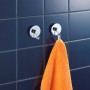 Wenko Vacuum-Loc Hakenset, 2 Chrom-Haken an blauer Wand, einer mit orangefarbenem Handtuch.