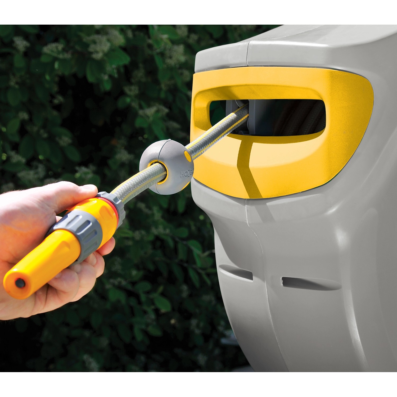 Hozelock Auto Reel Schlauchtrommel mit 30m Schlauch in Nutzung, gelb/grau.