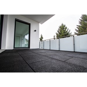 Verlegte, schwarze Terrasoft Fallschutzplatten auf einem Balkon. Rutschfester Bodenbelag für mehr Sicherheit.