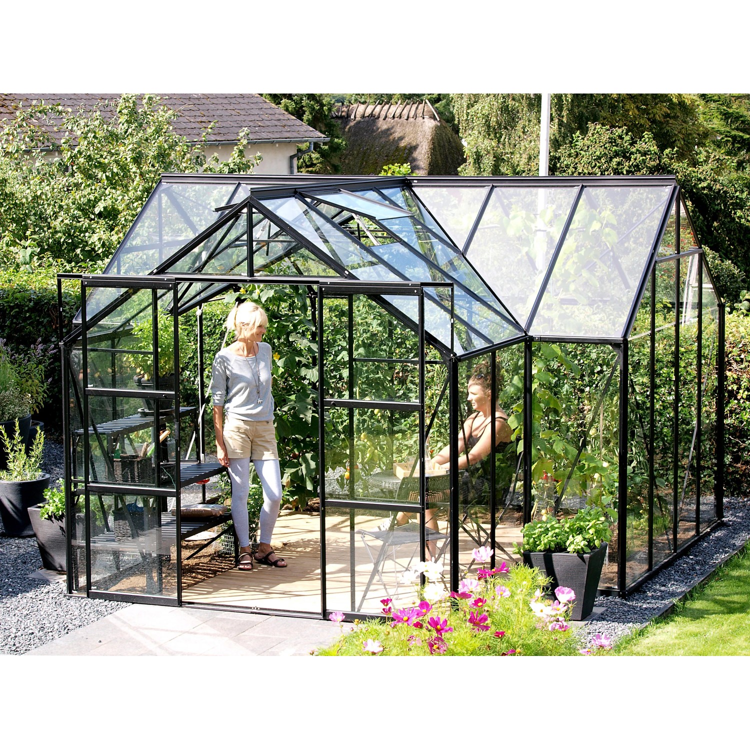 Schwarzes Vitavia Gewächshaus Sirius 13 m² mit ESG-Glas und Fundament im Garten.