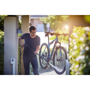 Mann reinigt Fahrrad mit Nilfisk Dreckfräse/Rough Düse Hochdruckreiniger.