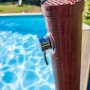 Gre Solardusche in Holzoptik (9 l) neben Pool, Detailaufnahme des Wasserhahns.