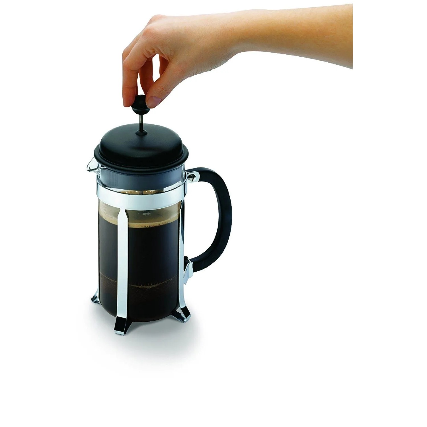 Hand drückt Kolben des Bodum Caffettiera French Press Kaffeebereiters. Glas, schwarzer Deckel, Chromrahmen. Für aromatischen Kaffee.