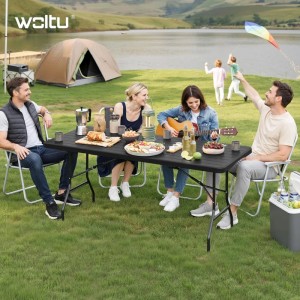 Schwarzer WOLTU Klapptisch Gartentisch mit Metallbeinen, klappbar, am Seeufer. Vier Personen genießen ein Picknick im Freien.