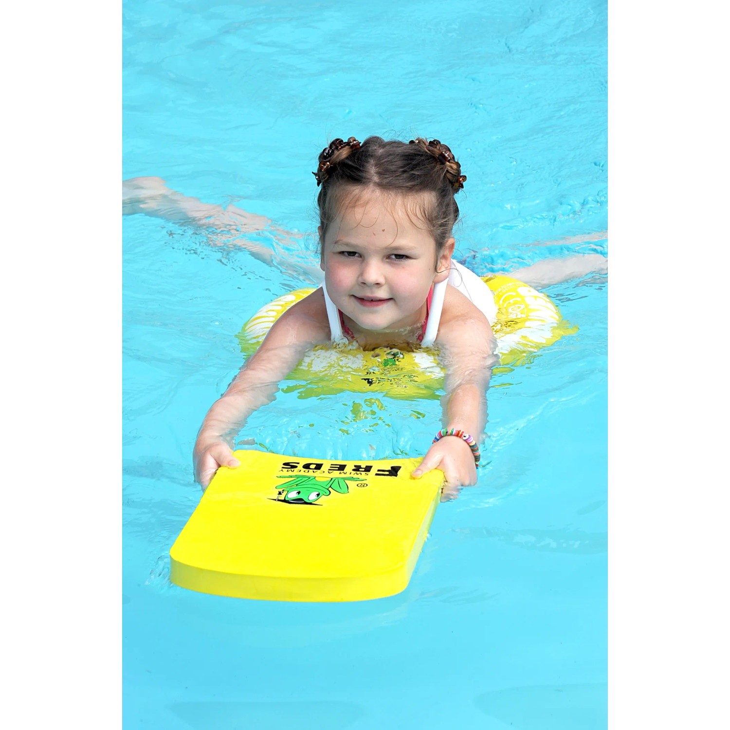 Mädchen mit gelbem Freds Swim Academy Schwimmreifen und Schwimmbrett im Pool (4-8 Jahre).