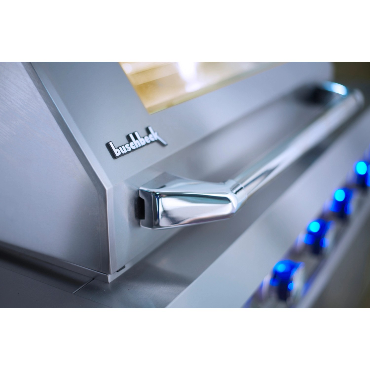 Detailaufnahme: Buschbeck Outdoorküche Oxford mit Edelstahlhaube, Griff und blauen LED-Drehknöpfen.